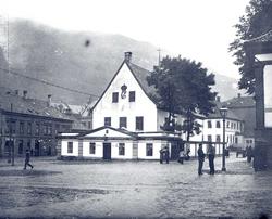 Bybilde fra Bergen, hvitt hus med kongekrone sentralt i bild