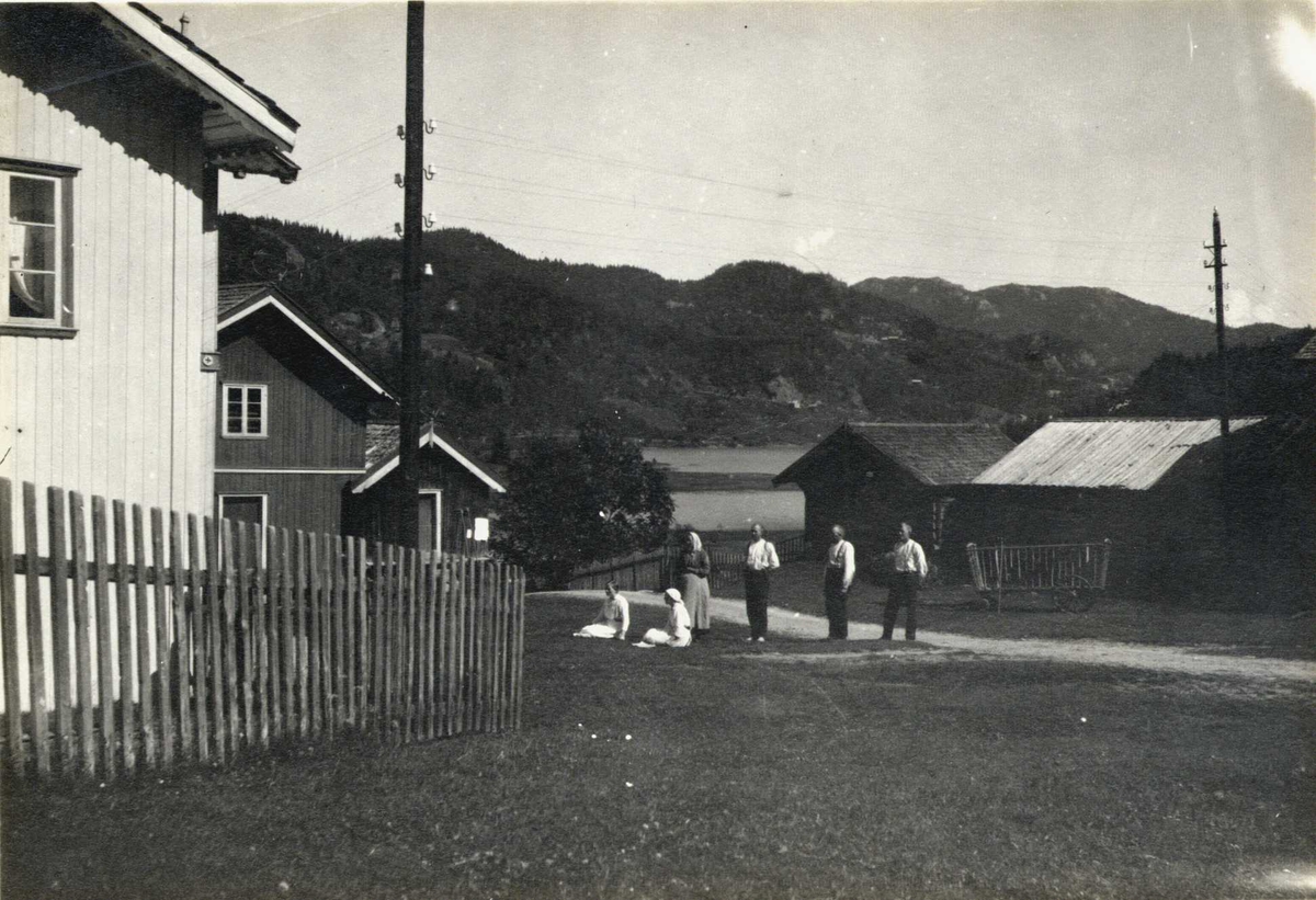 Gårdstun, Berge, Morgedal, Kviteseid, Telemark. Gruppe av kvinner og menn  på gårdsplassen. Fotografert 1917.