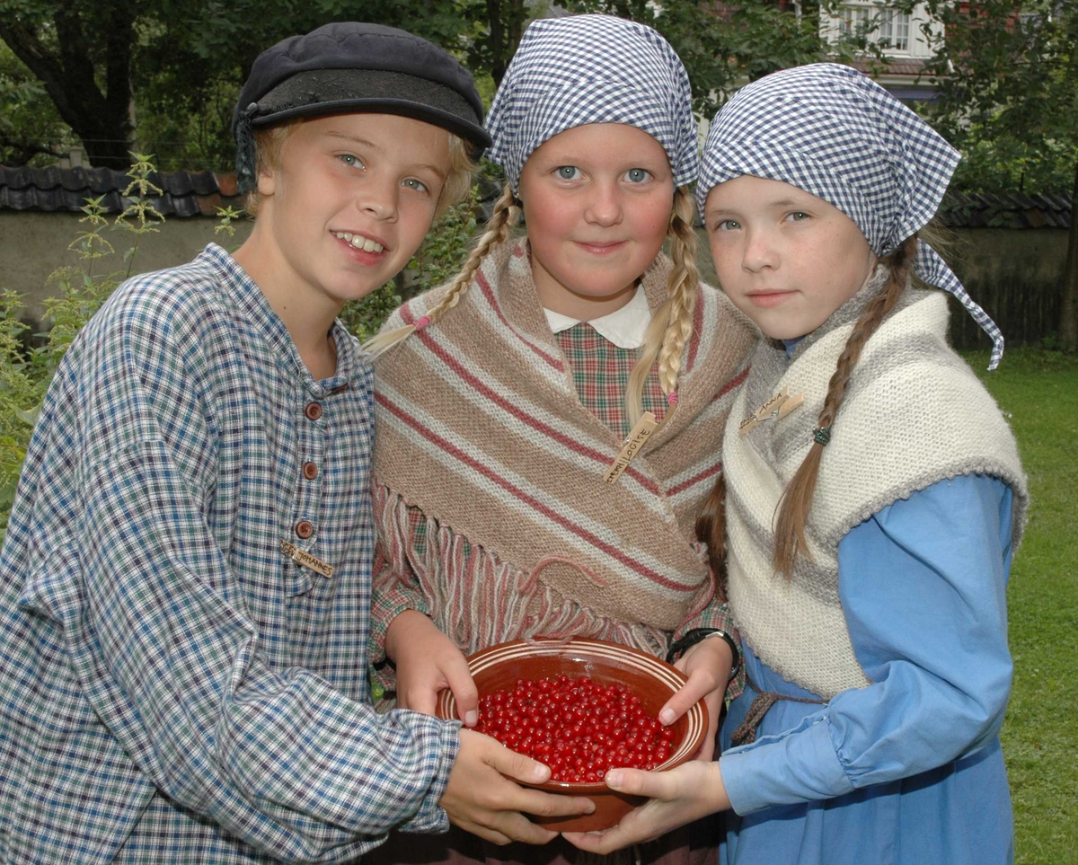 Levendegjøring på museum.
Ferieskolen uke 31 i 2005. To jenter og en gutt kledd i drakter med en bolle full av rips. 
Norsk Folkemuseum, Bygdøy.