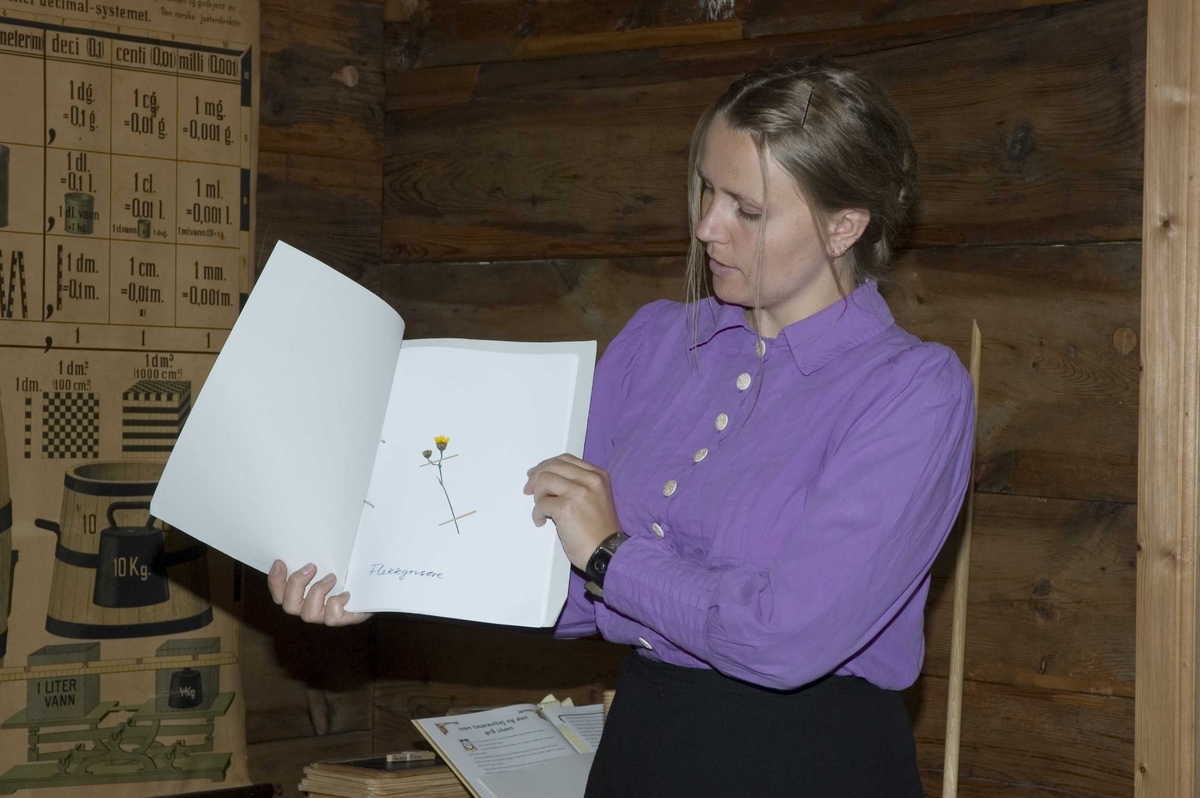 Levendegjøring på museum.Ferieskolen uke 31 i 2006. Læreinnen viser fram et herbarium.
Norsk Folkemuseum, Bygdøy.