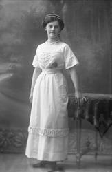 Portrett, kvinne med lys kjole og perlebånd i håret og om ha