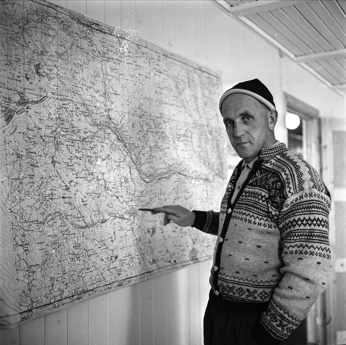 Imingdalen kraftanlegg, Nore og Uvdal, Buskerud, 15.12.1962. Portrett av ingeniør J. Meland ved kart.