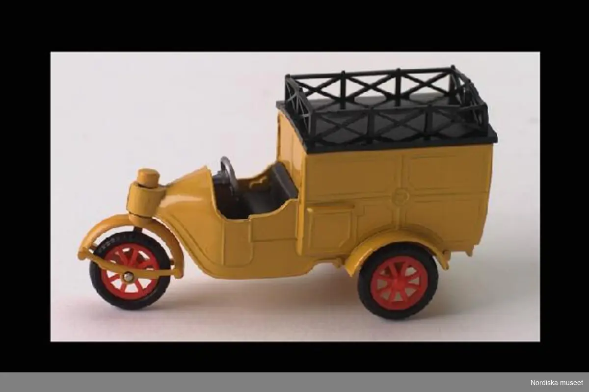 Inventering Sesam 1996-1999:
L 9,0 cm
B 3,5 cm
H 5,0 cm
Gulmålad tysk postbil av äldre modell, av metall med delar av plast (tak, säte, hjulnav och ratt). Trehjulig, vridbart hjul fram, öppen förarhytt, lastutrymme med öppningsbar bakdörr. Gjutet örnmärke på sidorna. Märkt: "MADE IN GERMANY". Originalkartong i rött, grönt och gult med texten: "GAMA/patent/Mechanic/MINIMOD/OLDTIMER NR 979/Nr 979 Postkutschen-Dreirad".
Inköpt hos AB Leksaksborgen, Östermalmstorg 2, Stockholm för 7,50 kr i Aug. 1965. Ursprungligen avsedd för Nordiska Museets utställning "FÄRG", men aldrig använd.
Helena Carlsson 1996