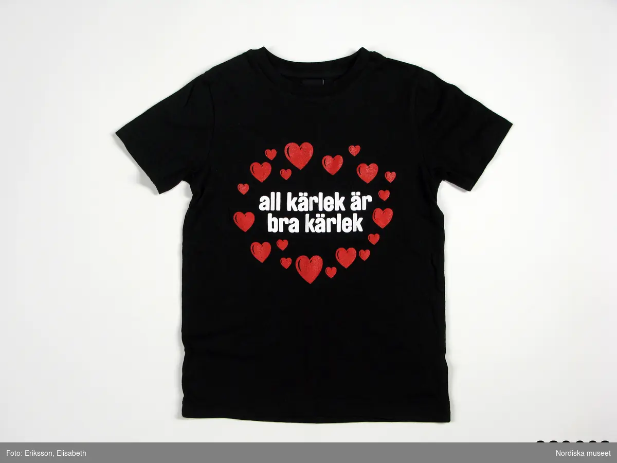 Tröja, svart t-shirt av 100% bomull, för barn, kort ärm. På framstycket tryck av plast i form ring av röda hjärtan och vit text "alla kärlek är bra kärlek". På ryggen i vitt mp.se. Etiketter i halslinningen "dem colletive" och storleksangivelse "M". Etikett i sidsöm med tvättinstruktioner och text: "A DEMI COLLECTIVE PRODUCT / FAIR TRADE AND ECOLOGICAL PRODUCED / MADE IN SRI LANKA / 100% COTTON / M".

T-shirten är tillverkad för Miljöpartiet och deras deltagande i Stockholm Pride mm. Stockholm Pride är den största årliga festivalen för HBT-personer i Sverige och som 2008 firades 25 jul.-3 aug. Detta år var Stockholm Pride även värd för Europride. Under Stockholm Pride / Europride 2008 användes dessa t-shirts bl. a. av de som gick i Miljöpartiets grupp i den stora paraden som går genom centrala Stockholm och som är en del av firandet samt av dem som tjänstgjorde i Miljöpartiets tält i Pride Park. Devisen "all kärlek är bra kärlek" har Miljöpartiet använt sig av sedan några år i debatten om könsneutrala äktenskap, vilket Miljöpartiet är positiva till.

T-shirten är tillverkad i 100% miljövänlig/ekologisk bomull av företaget dem collective som tillverkar miljövänliga och rättvisemärkta kläder. Under 2000-talet har produktionen av miljövänliga kläder ökat, även om den är en försvinnande liten del av den totala produktionen av kläder. Men ett antal mindre företag har profilerat sig med tillverkning och/eller försäljning av miljövänliga kläder. Även en del större företag såsom t.ex. Hennes & Mauritz har ibland några enstaka miljövänliga plagg. Det har under de sista åren även kommit en del produkter som inte bara är tillverkade med tanke på miljön utan även tillverkade under drägliga förhållanden för dem som tillverkar produkterna. En produktmärkning, kallad rättvisemärkning eller Fair Trade, har också tagits fram som garanterar detta.

Föremålet ingår i Nordiska museet dokumentation av Europride/Stockholm Pride 2008 med intervjuer, fotografier och föremål. Se vidare arkivet (D.457). I bilagan finns utskrift från DEMIs hemsida med deras produkter och tillverkningsfilosofi.
/Leif Wallin 2009-06-17