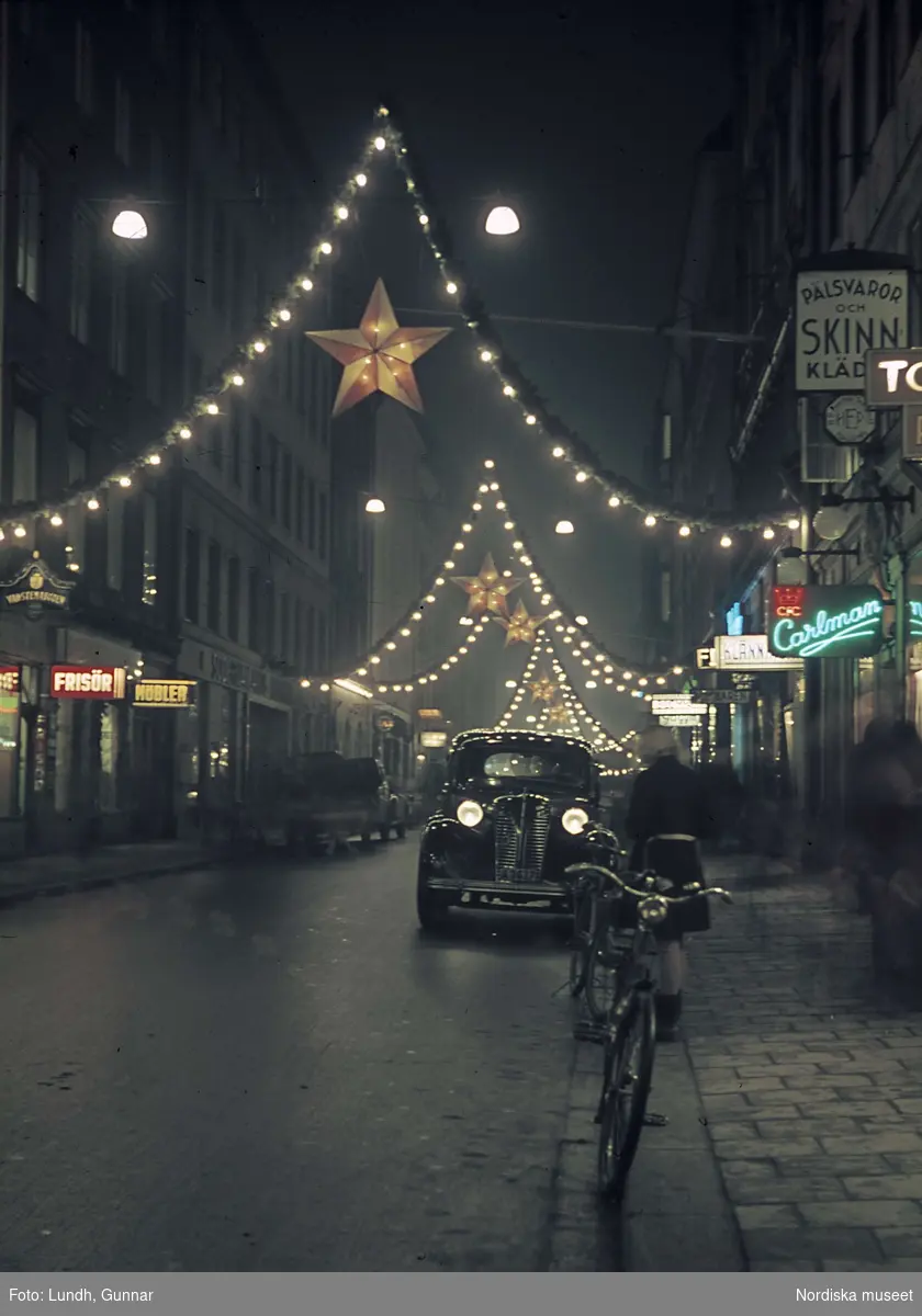 Julbelysning på Regeringsgatan, Stockholm.  Bil och cykel i förgrunden.