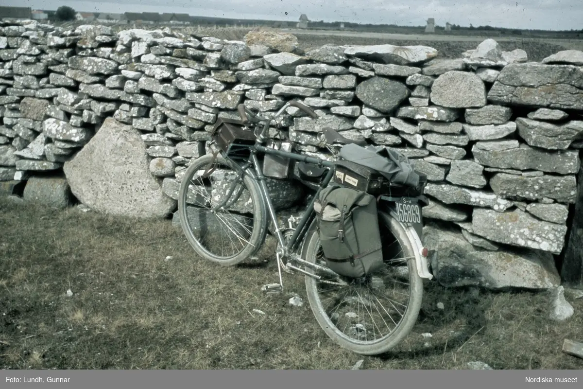Cykel som står lutad mot en stenmur.