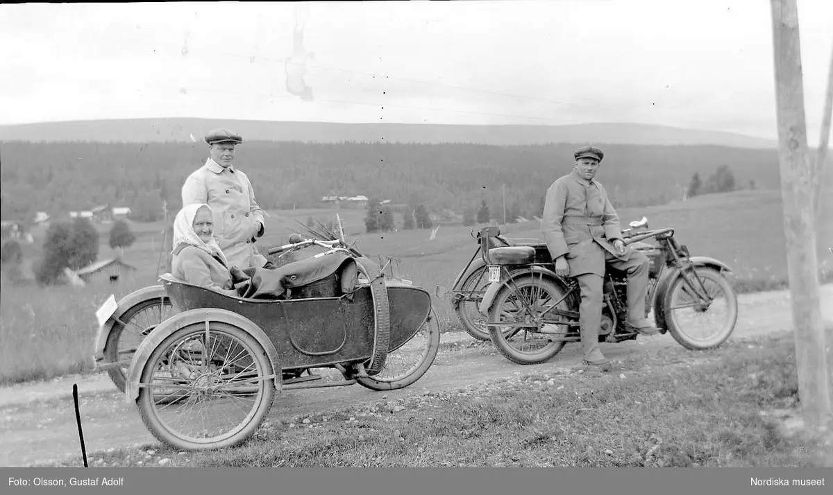 Två män och en äldre kvinna med motorcycklar med sidovagn på landsväg. 1920-talet.