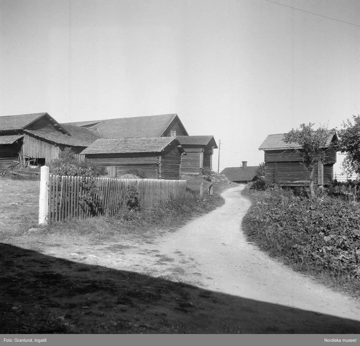 Pergården (tidigare Sjonsgård) i Osmundsbergs by i Boda socken, Dalarna. Byggnader på var sida om en grusväg.