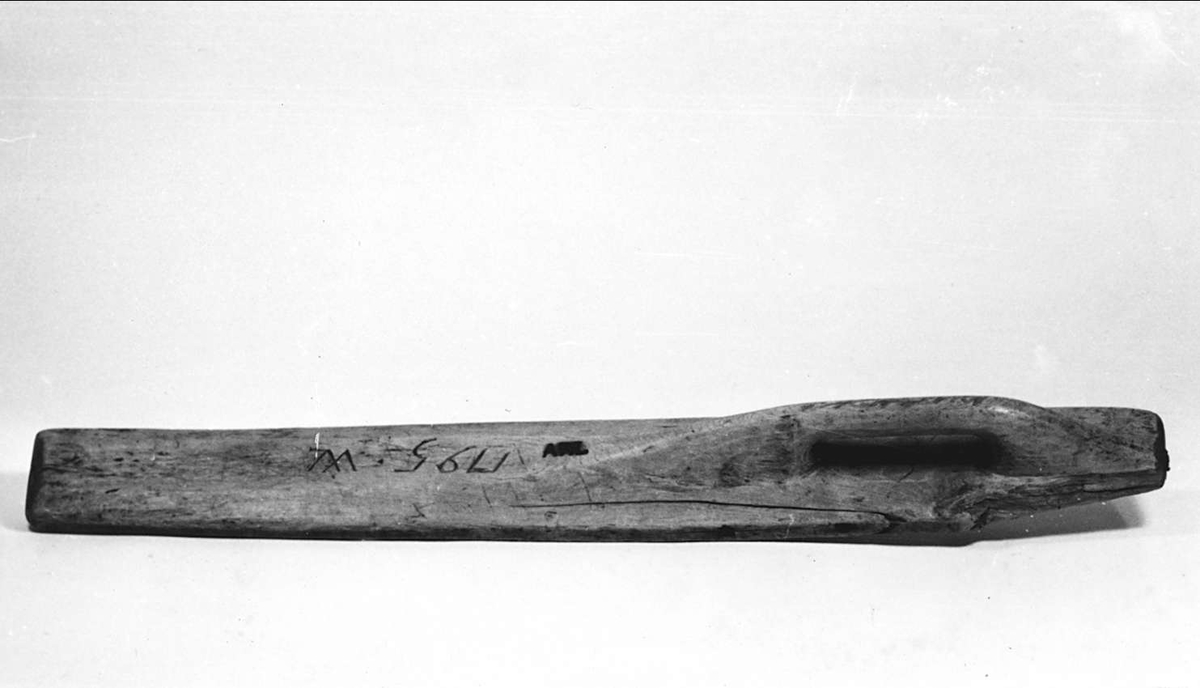 Mangelbräde av trä. Inristat: 1795 W. Handtag och bräde i ett stycke. 
