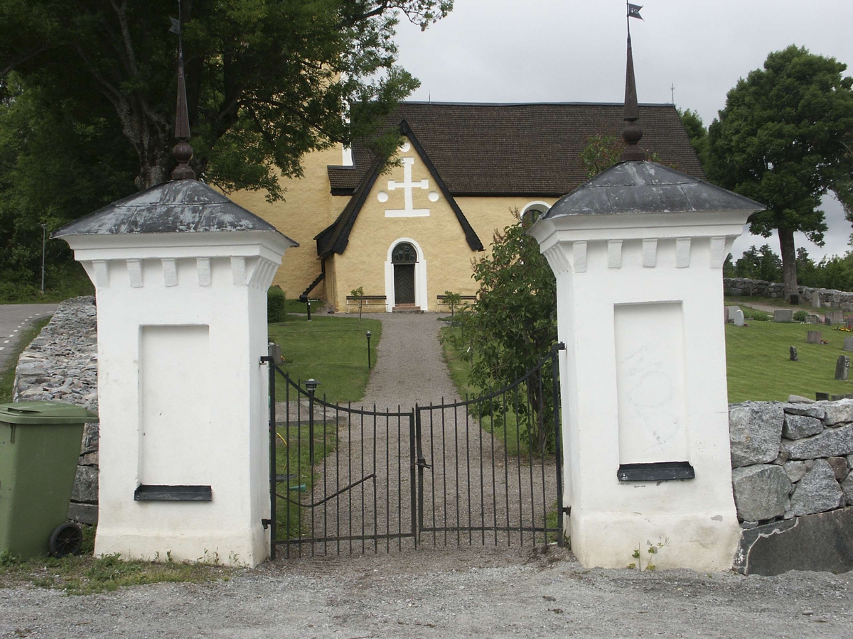 Huvudingången med vitkalkade grindstolpar vid Häggeby kyrka, Häggeby socken, Uppland 2005