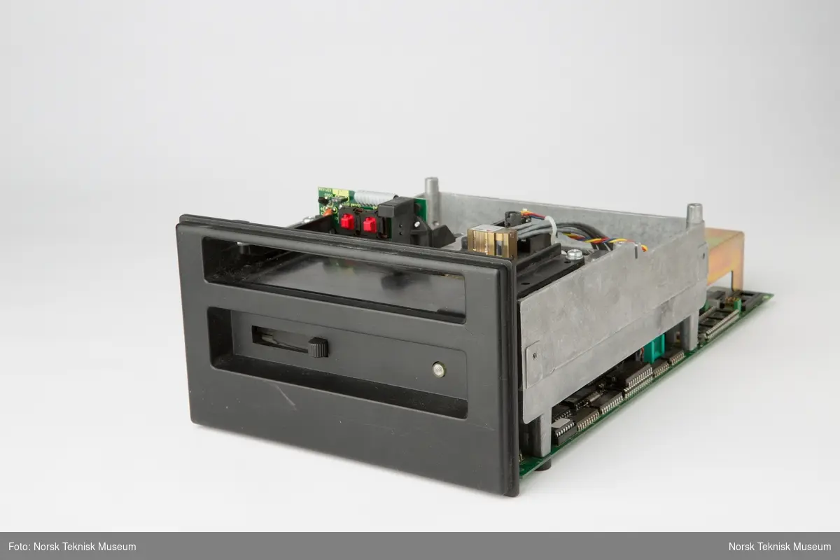Eske med én transformator og åtte ulike datasteamere / tape drivere produsert av Tandberg data og Tandberg Storage. Noen er demonstrasjonsmodeller med plexilokk.