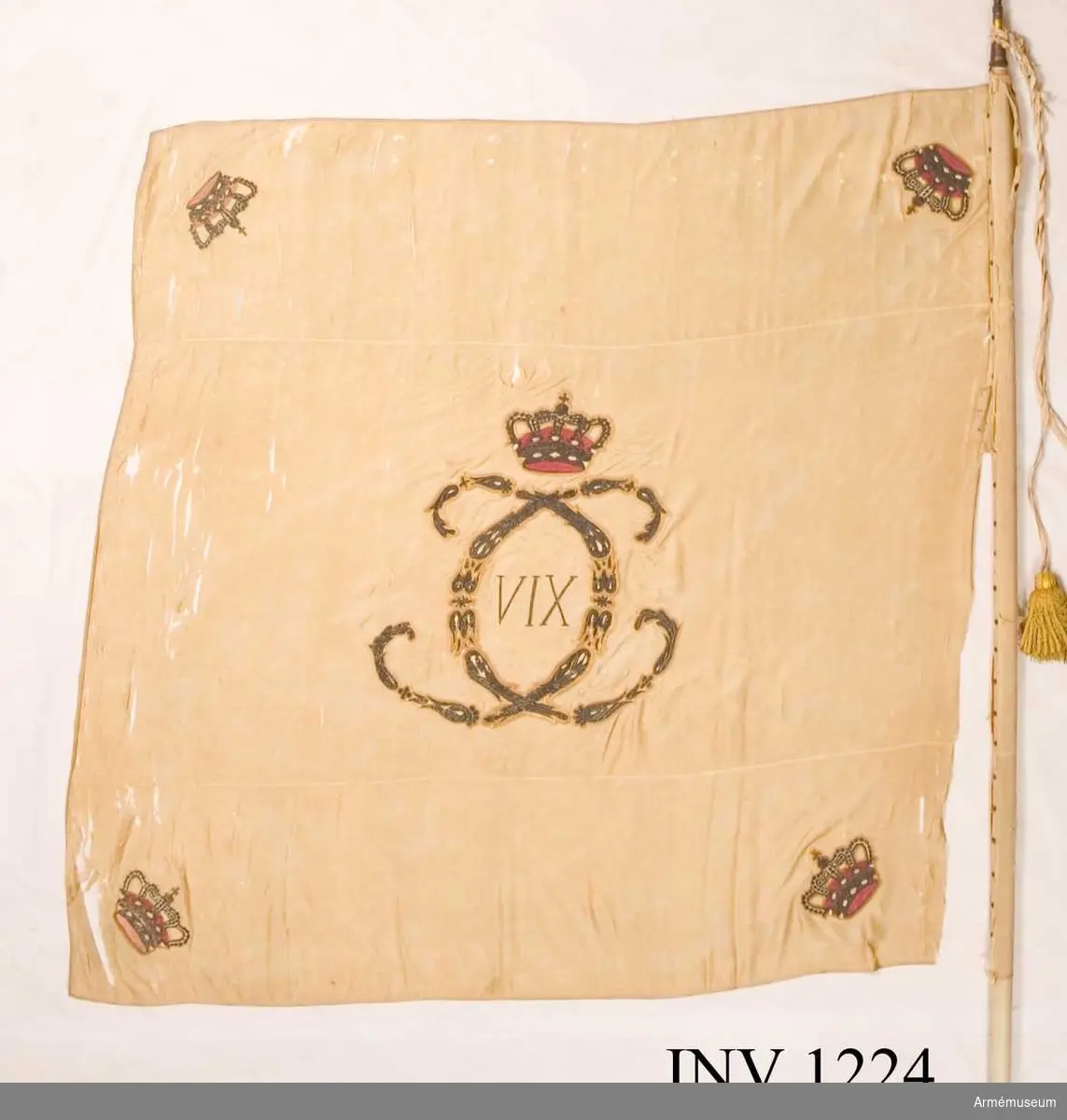 På det gulvita kyprade fansidenet sitter i mitten ett broderat monogram föreställande två motställda "C" inneslutande "XIV". Broderiet utfört i plattsöm med silke och silvertråd. Ovanför monogrammet sitter en kunglig krona utförd i plattsöm med foder i rött silke. I fanans hörn sitter snedställda kronor i rött silke. Fanspetsen har Karl XIV Johans monogram, dock mycket ärgat. Fanstången är gulvitmålad. Kravatten, den lilla del som återstår, är uppsydd på ett bomullsband.