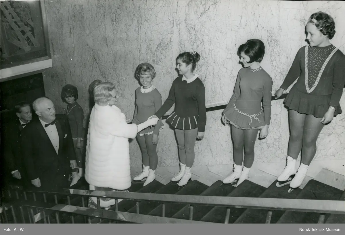 Sonja Henie hilser på skøytere oppstilt i trappen på Hotel Bristol i forbindelse med måltid etter dåpsseremoni for tankeren M/S Sonja, B/N 560 på Akers Mek. Verksted 9. november 1965. Skipet ble levert 11. november 1965 til Onstad Shipping A/S.