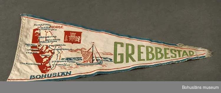 Trekantig vimpel med textiltryck i rött och blått med Bohusläns vapen och landskapskarta samt seglande båt, namnet "Grebbestad" i grönt. Blå kant. En kant stadkant, en skuren och en fållad.
Sammanhör med UM026180-UM026184
Användar- och förvärvsuppgifter se UM026180