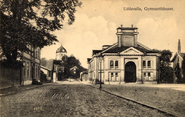 Tryckt text på vykortets framsida: "Uddevalla Gymnastikhuset." 
"Maria Lundbäcks Ateljer."