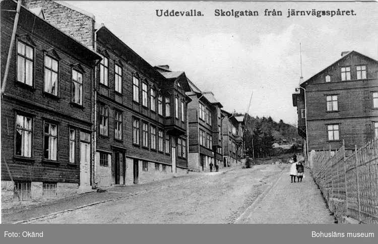 Tryckt text på vykortets framsida: "Uddevalla, Skolgatan från järnvägsspåret."
