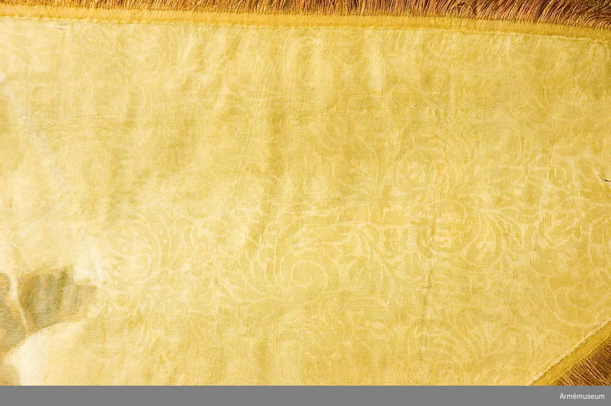 Grupp B.

Duk av brandgul damast, varå är målat, omvänt lika å båda sidor ett griphuvud i brunt, krönt av en öppen krona i silver. Runt kanten löper en 45 mm bred frans av gult (?) och rostbrunt silke; duken är fäst vid stången med gult sidenband och förgyllda mässingspikar.Stång av furu, niosidig med tre refflor och tre förstärkande  skenor ovan greppet, nedtill avsågad, i senare tider blåmålad, stången är försedd med en 80 mm hög konisk klack av järn samt  med löpande bärring. Stång 2750 mm, till greppet 460 mm, greppet 190 mm, till duken 1040 mm. Diameter upptill 32 mm, nedom duken 50 mm, ovan greppet 62 mm i greppet 55 mm. Spets av  förgylld mässing, bladet snedböjt.
