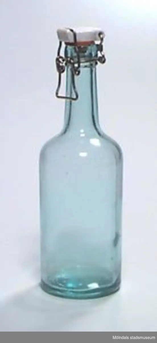 Äldre glasflaska med fastsittande porslinskork (-lock) av den typ som går att öppna och stänga med ståltrådsbygel. Rymmer ca 0,5 liter. "ÅRNÄS" i botten av flaskan.Ägaren är faster till givaren.
