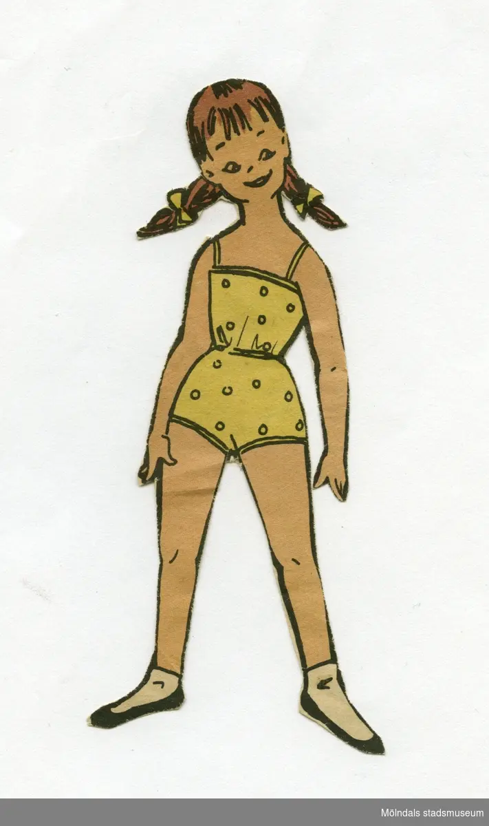 Klippdocka, urklippt ur tidning på1950-talet. Dockan föreställer en flicka med brunt hår i flätor, iklädd underkläder i baddräktsmodell, strumpor och skor. 