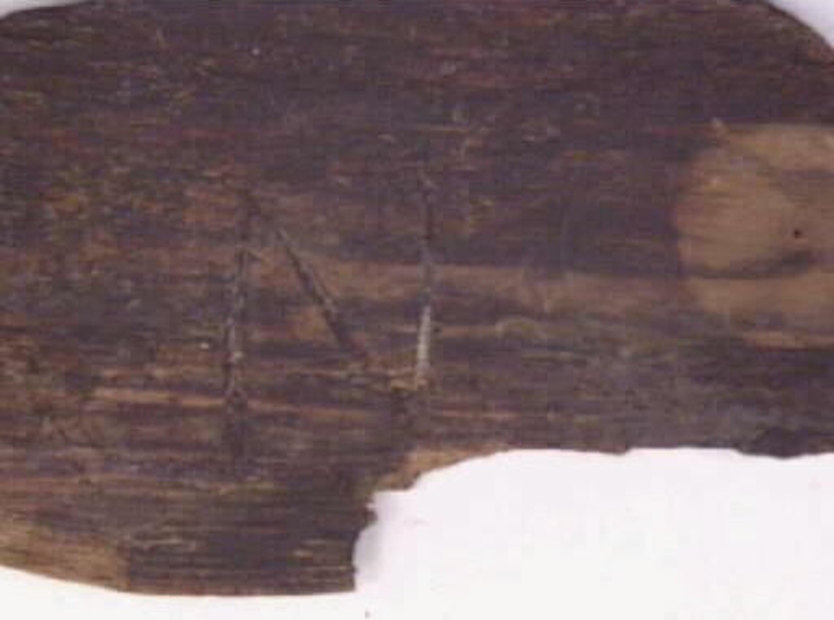 En oval botten till en svepask. Kanten är fasad och har fyra kvarsittande träpligg. Bottnen är försedd med ett bomärke: N. Bottnen är sliten och bruten.