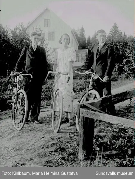 Kvinna och två män med var sin cykel.