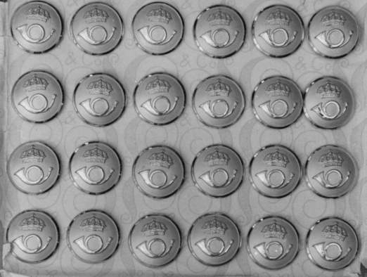 Uniformsknappar, 24 st. Förgyllda metallknappar med postens
symbol i relief mot streckad grund inom en smal och slät kant,
mellanstorleken, bottnade. Cirkulär nr 28 den 12 maj 1937.
Artikelnumemr 2596/1949.