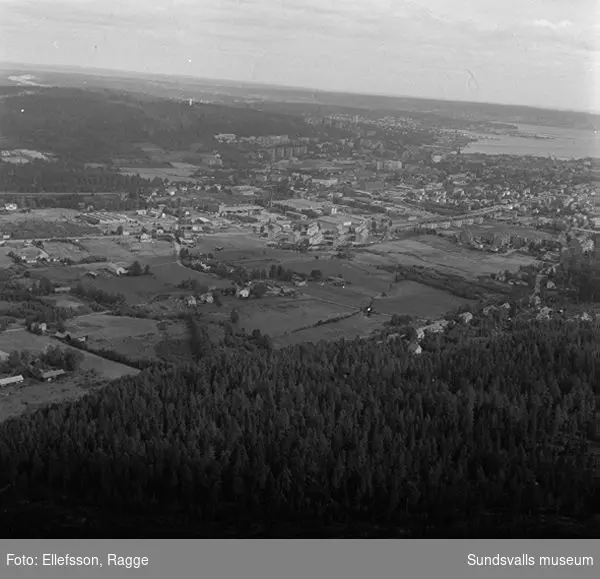 Flygfotografi över Nacksta by 1964 före byggnationen av Nacksta centrum. Kommunen löste in marken 1963.