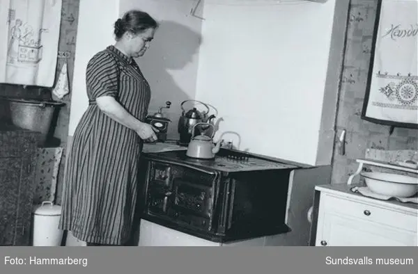 Louisa Hammarberg, fotografens hustru, kokar kaffe på vedspisen.