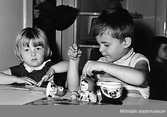 Två barn leker med en rysk docka vid Holtermanska daghemmet 1953.