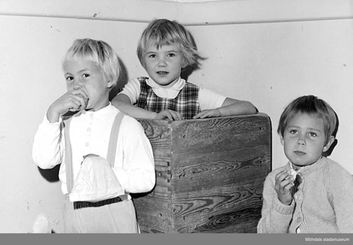 Tre barn som leker med stapelbara trälådor. Holtermanska daghemmet 1953.
