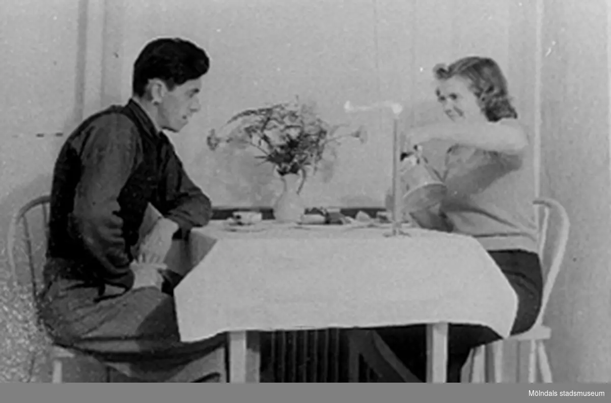 Bilden är tagen på Karl och Lilly Nygren under en kaffepaus hemma cirka 1946 - 1947. Under fotot står "KAFFE ÄR GOTT".
