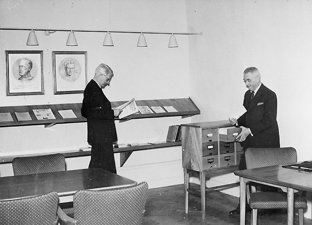 Filatelistiska bibliotekets läsrum, på 2 trappor.(Rummet beläget
mot Lilla Nygatan, med ingång från bl a rum nr 1). Aktuarie P.G.
Heurgren (t.v.) och direktör Nils Strandell.