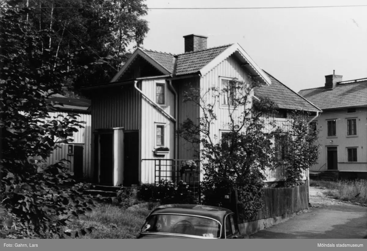 Roten F25, år 1986-1987. Fastigheten saknar gatuadress men skulle ha varit en del av Myntgatan. En Amazon står parkerad på gatan.