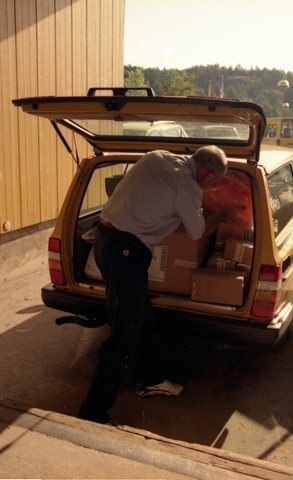 Lantbrevbärare Reinhold Andersson paketerar utgående post i postbil
vid en postanstalts lastkaj. Tillhör en dokumentation av en
lantbrevbärare i trakten av Valdermarsvik av fotograf Ove Kaneberg.