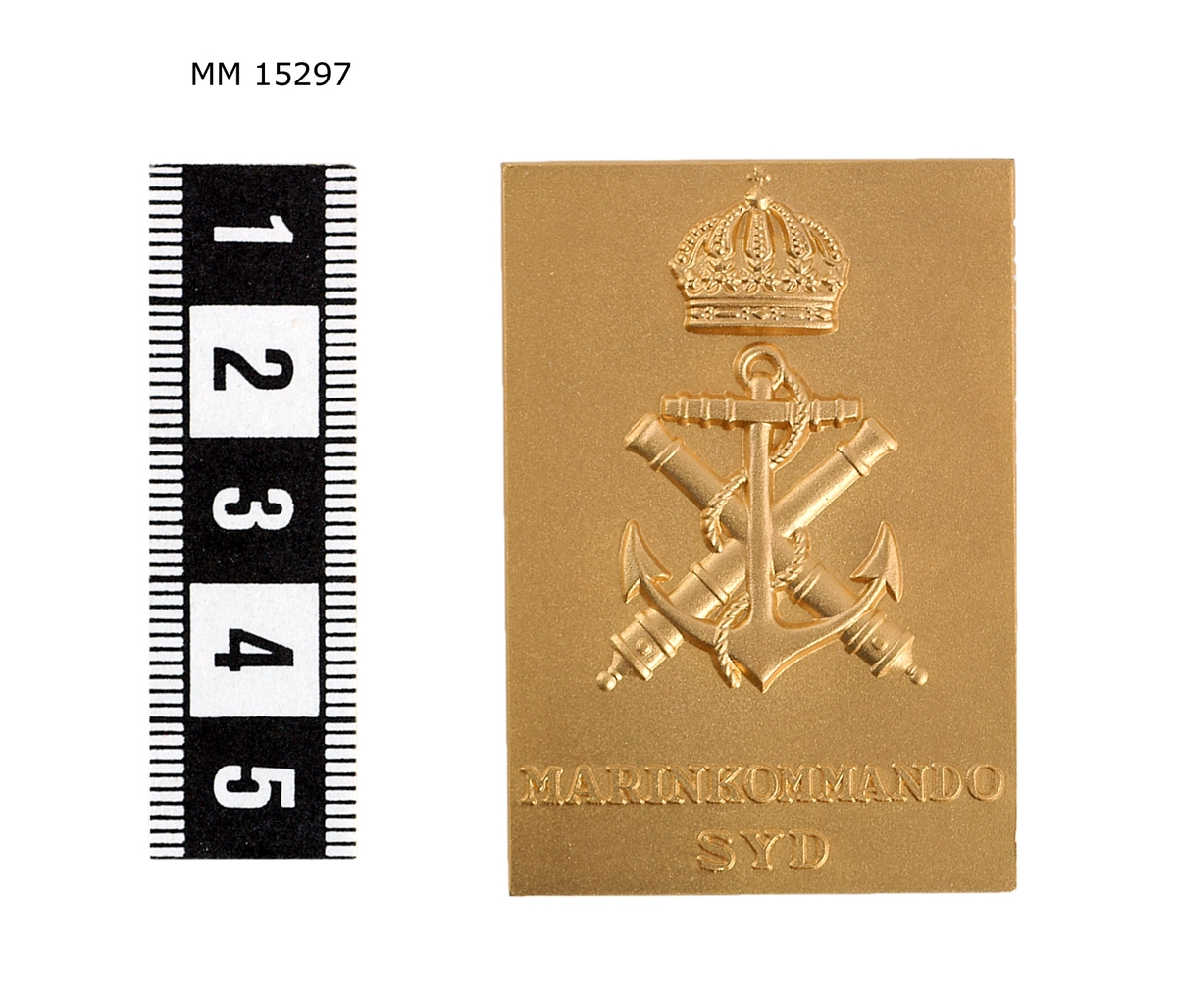 Raktangulär, matt platta med på åtsidan marinens emblem, över detta en sluten kunglig krona, under står: MAINKOMMANDO SYD. På frånsidan stämpel: LAGERSTRÖMs MJÖLBY.