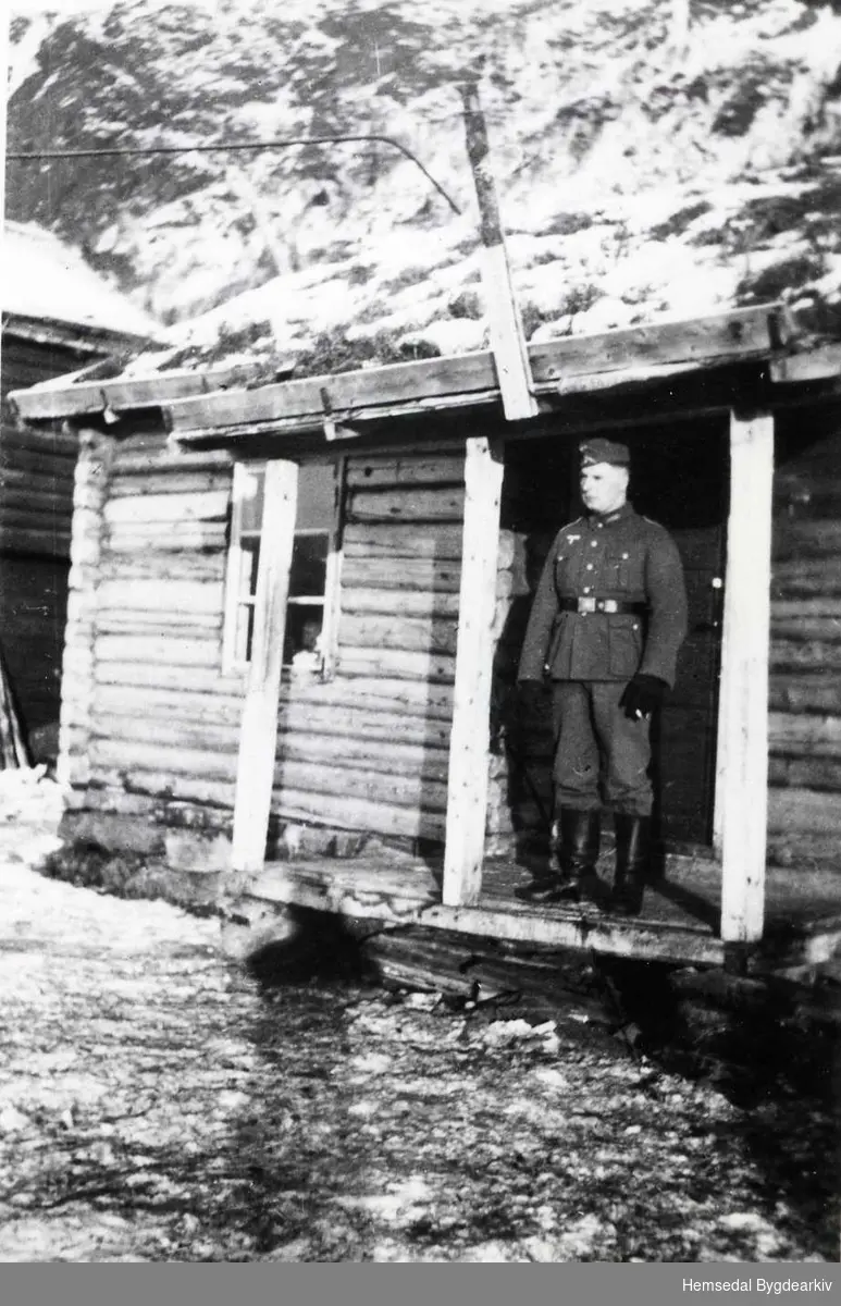 Tysk soldat  i 1941 på Ulsåk i Hemsedal. Før tyskarane fekk eigne brakker, budde dei i hus på gardane i bygda. Dette huset vart rive i ca. 1970.