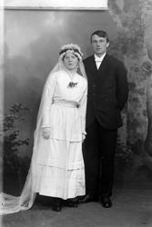 Studioportrett av et brudepar i helfigur.