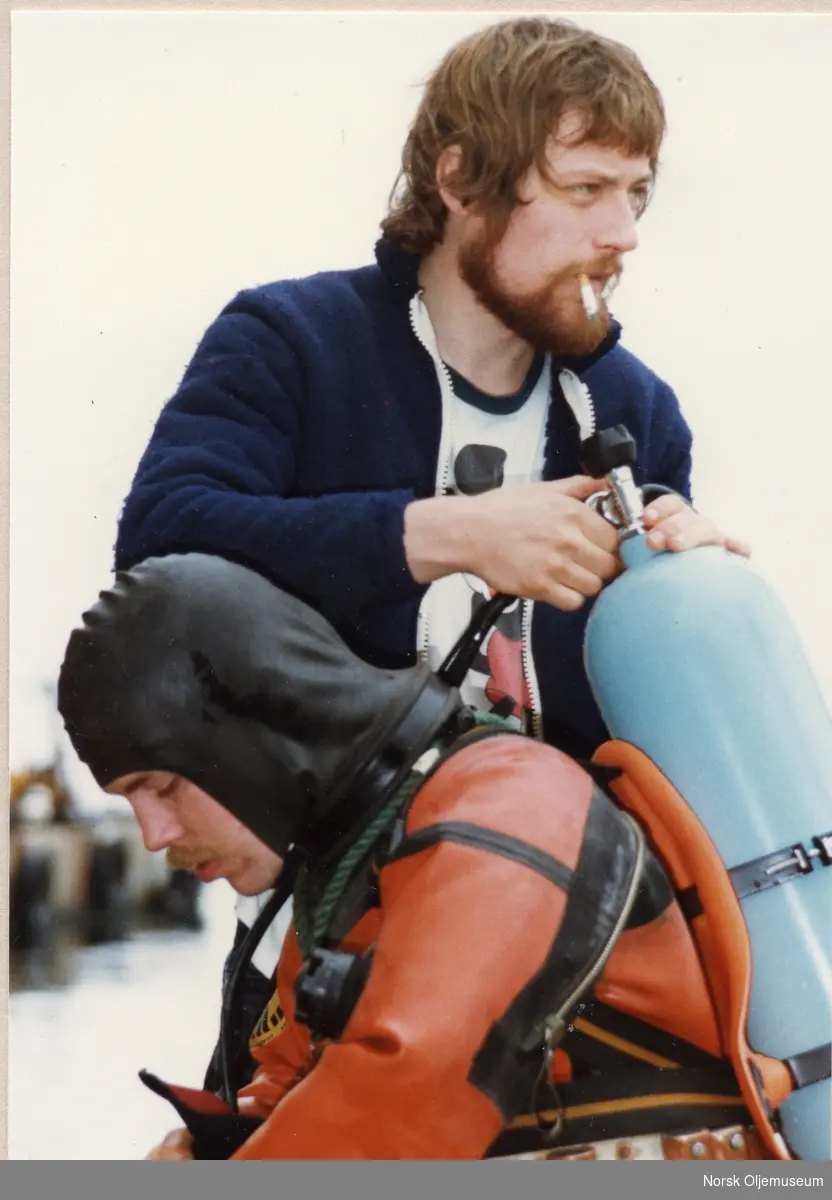 Yngve Tveit gjøres klar til dykk, Jan Warloe hjelper til.
Fra Condeep "Dowel job" i Gannsfjorden ved Stavanger i 1979. Dykkerselskap: Willco as.