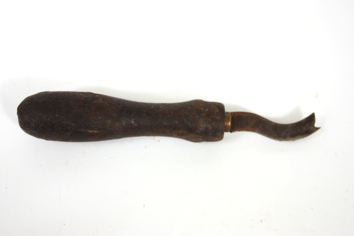 Form: Rundt trehandtak med bølga jern med skjær mellom tindane i gaffelforma ende
