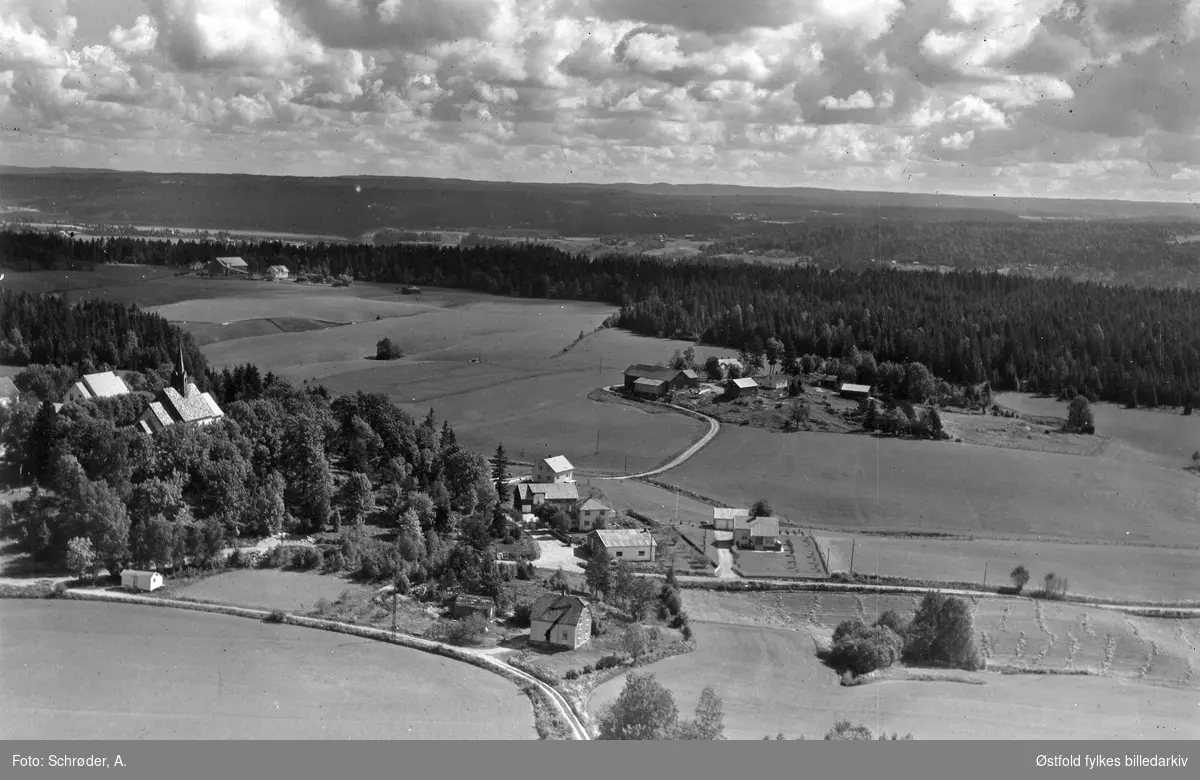 Ruene  i Skiptvet, flyfoto 11. juni  1959. Bussgarasje og Mørk Biltuter. Skiptvet krike i bakgrunnen.