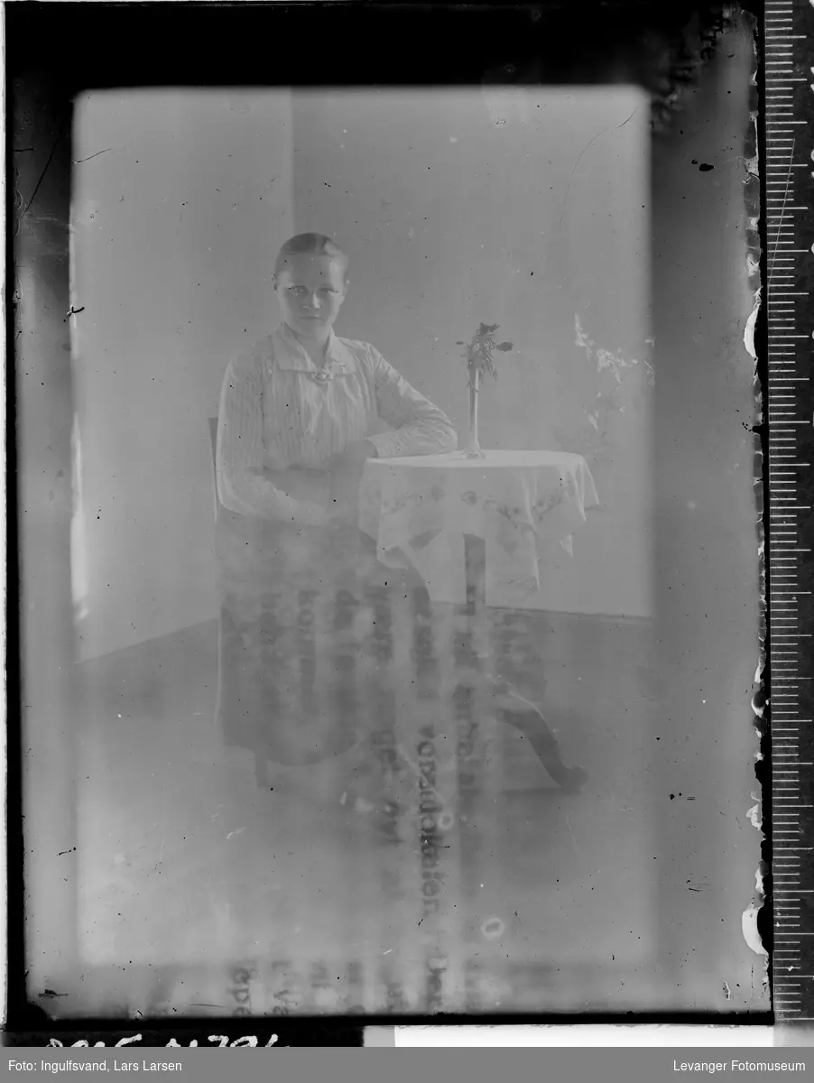 Portrett av en kvinne ved et bord.