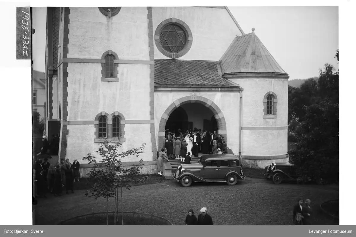 Brudeparet Martens foran Levanger Kirke. Bilen foran trappa er en Chevrolet 1934-modell.