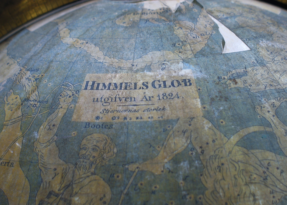 En himmelsglob med stjärnhimlen med dess stjärntecken. Himmelsgloben saknar ställning. Globen är från år 1824. Illustrationerna på globen föreställer bland annat stjärnor och stjärnbilder såsom Jungfrun, Vattumannen, Örnen, Tjuren, Draken etcetera.