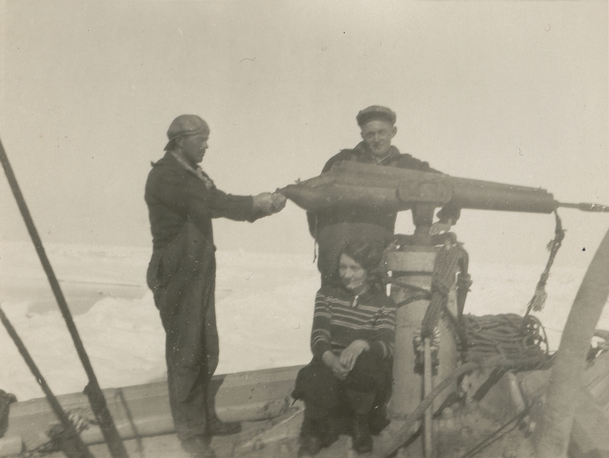 Tre av mannskapet ombord "Veslekari" poserer ved harpunkanonen.
