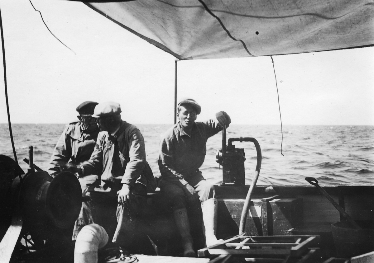 'Kattegattexpeditionen 1933: ::  :: 3 st män sittande vid pumpen, på däck ombord på en båt, Leonard Axel Jägerskiöld (längst till vänster), Hugo Oldevig (i mitten) och Sune Swärd (till höger). ::  :: Ingår i serie med fotonr. 2804-2826.'