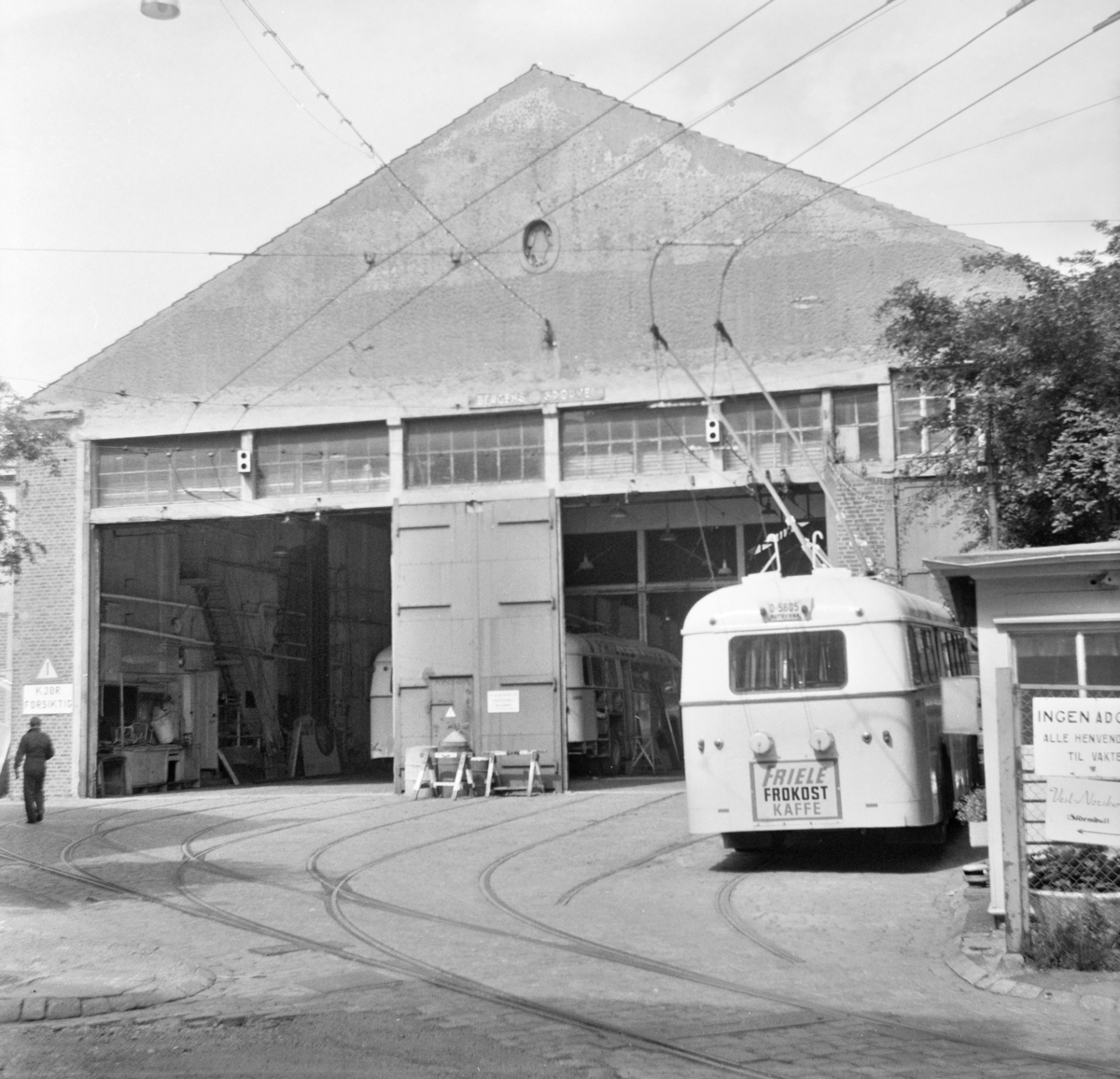 Bergen Sporveiers trikkestall er gjort om til garasje for trolleybusser. Trolleybyss type Munch står foran garasjen.
