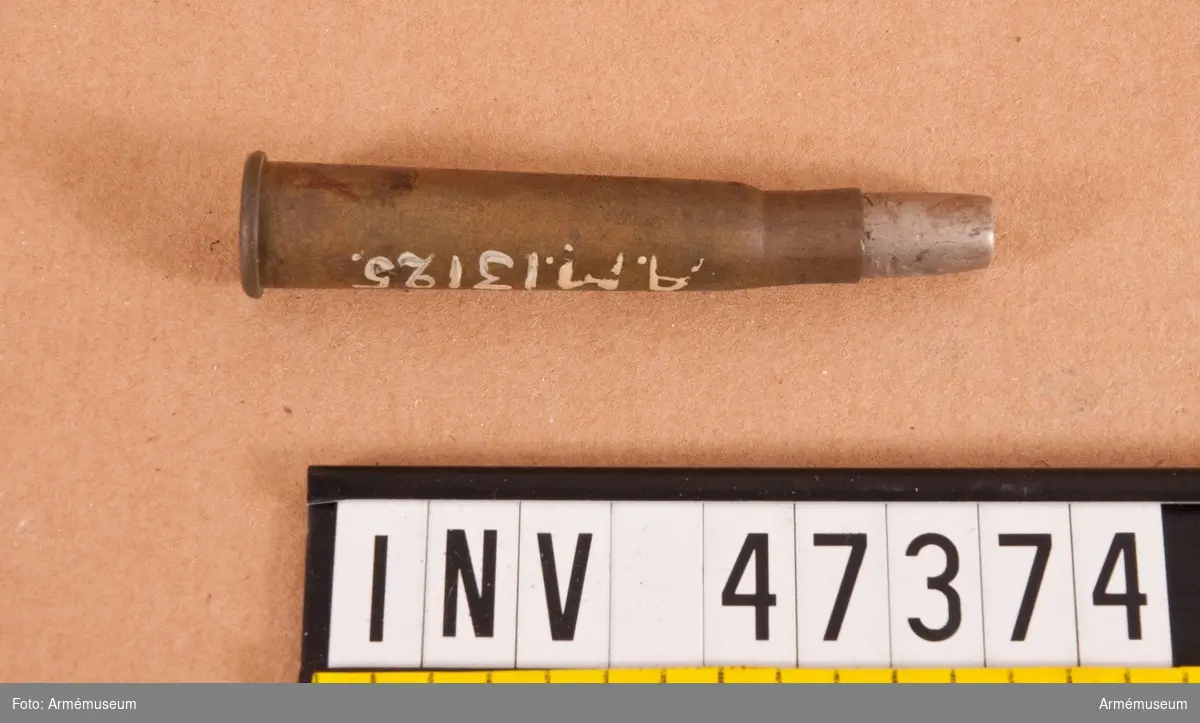 Grupp E V.
7,5 mm skarp patron, märkt R.L/VII. Till engelskt armégevär. Lik AM 47372, men med spetsen nedfilad till dumdumkula. Från första världskriget.