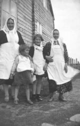 To damer og to jenter fotografert utenfor et bygg i Nyhamn i