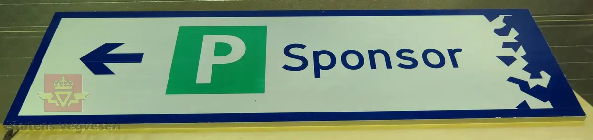 Rektangulært skilt av aluminium. Har symbol for kjøreretning og parkeringsplass samt teksten "Sponsor". Flerfarget, med grå bakside.