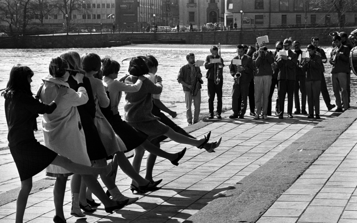 Våren 29 april 1966

Åtta stycken unga flickor står i en lång rad och dansar till en mässingsorkester som spelar i Centralparken i Örebro.